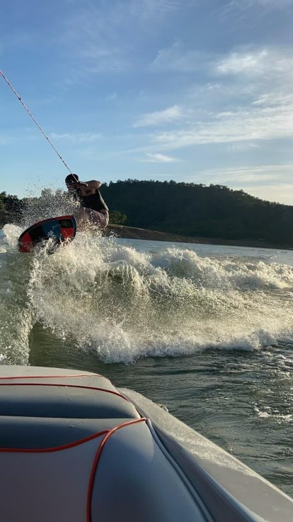 brad surfs the wake behind the malibu on lake nacimiento, california