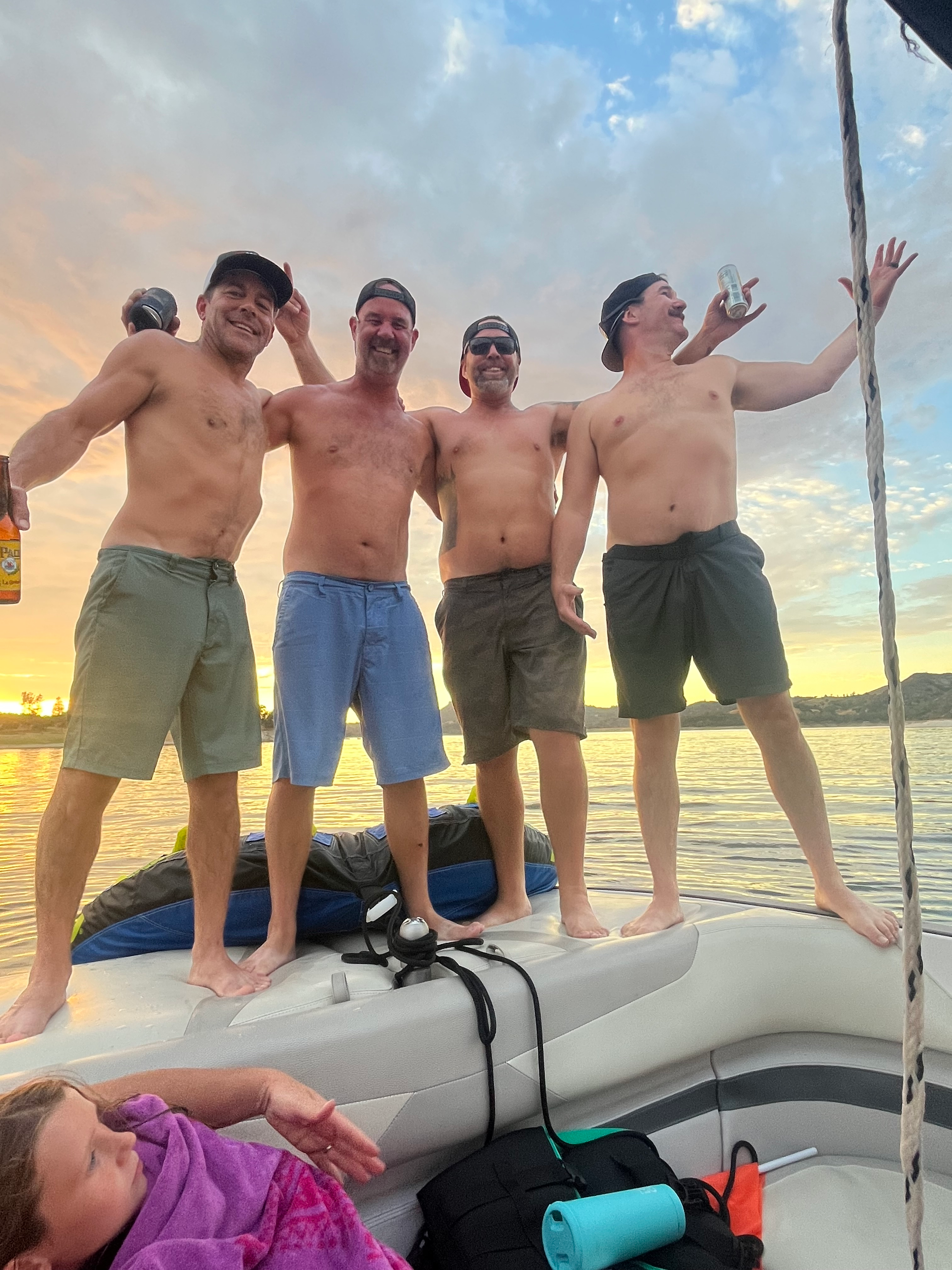 some dudes enjoying the sunset on the boat arm in arm